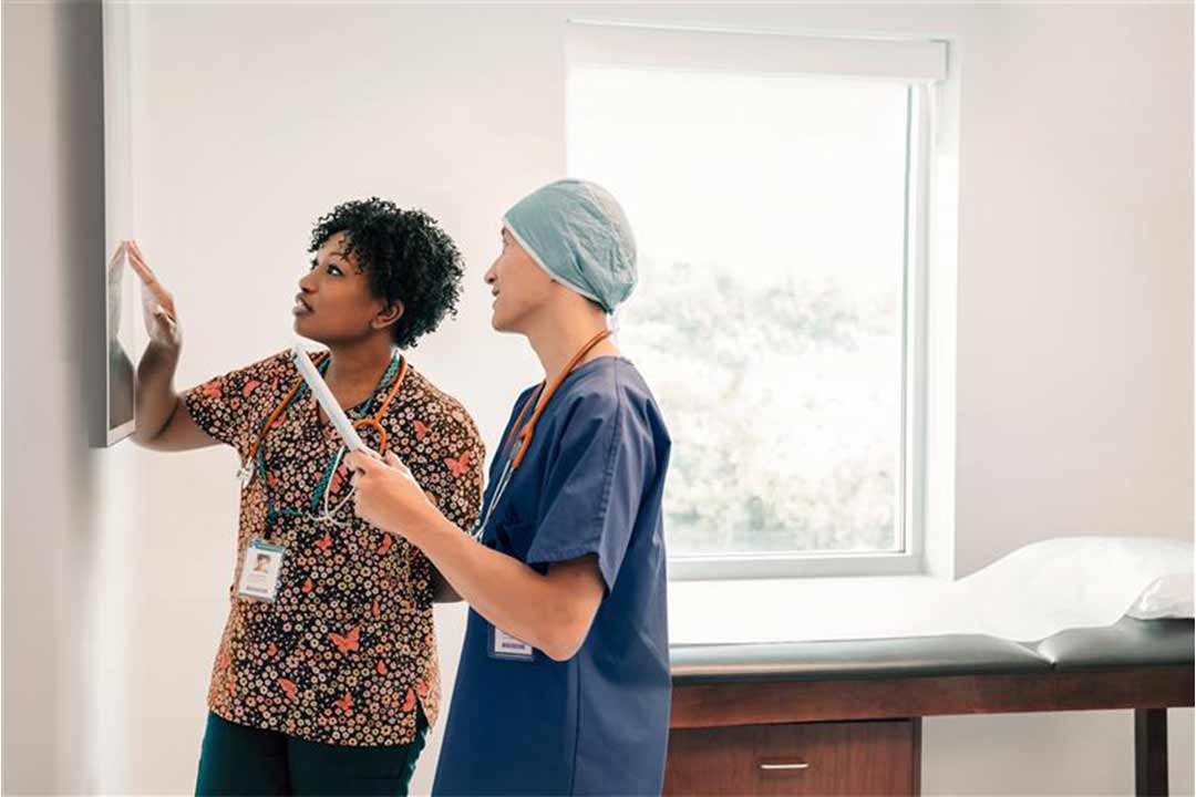 Two doctors looking at a flat screen in an examination room