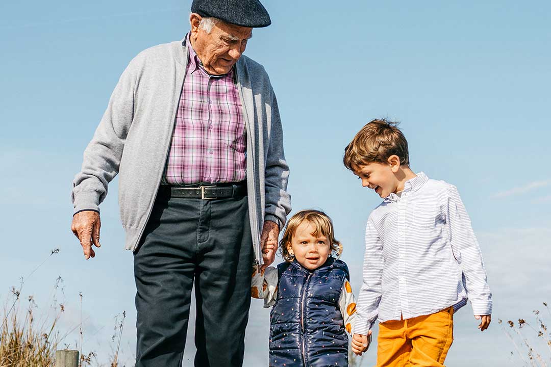 Active grandfather walking with young boy and girl